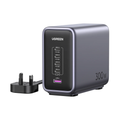 UGREEN 300W dual USB-C power bank in dark gray with a black front panel showing port details, accompanied by a black UK three-pin power adapter on a white background.