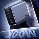 UGREEN 300W portable power bank in metallic silver with a black front panel showing multiple USB-C and USB-A ports, set against a dark blue and black background with '300W' text.